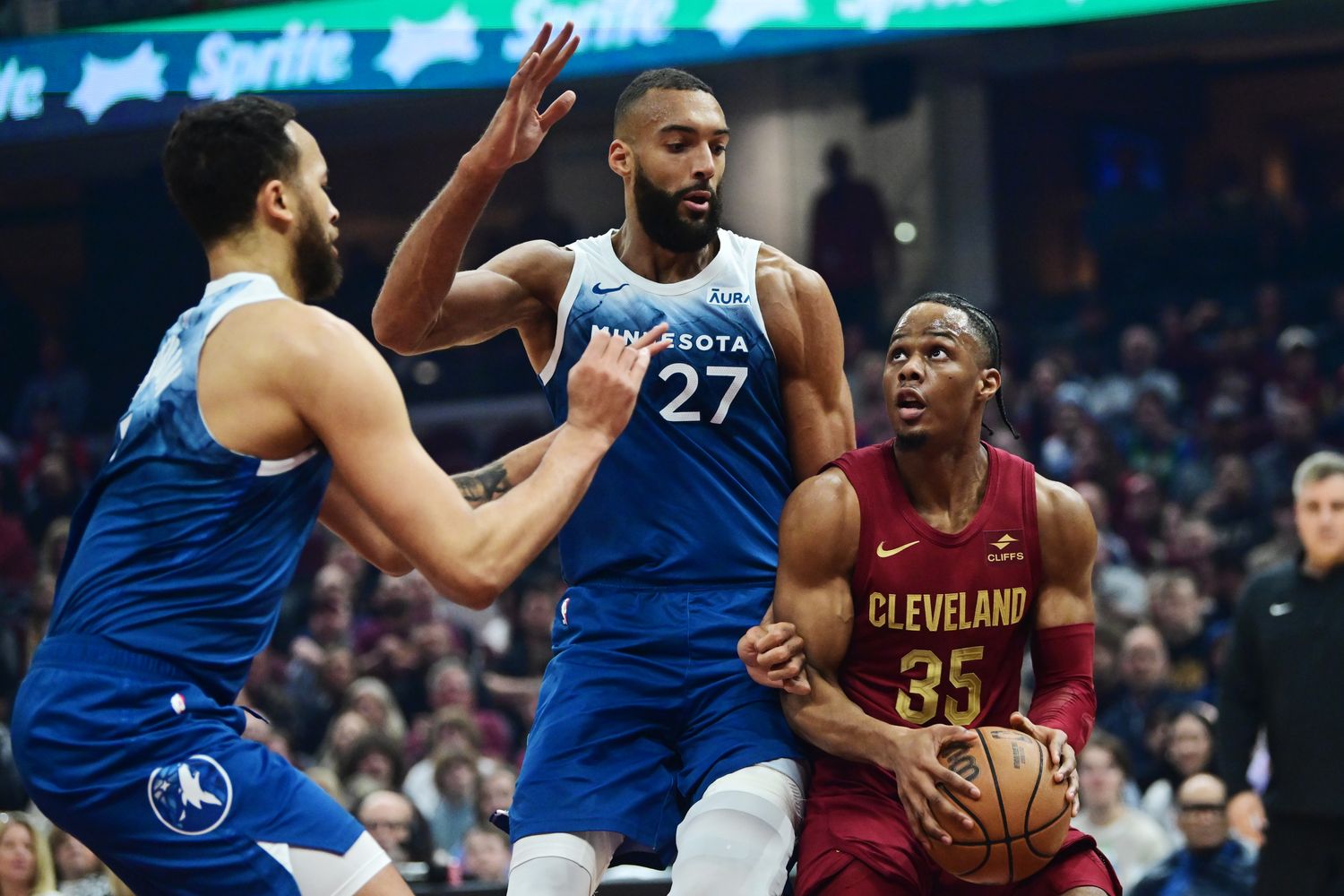 Mar 8, 2024; Cleveland, Ohio, USA; Cleveland Cavaliers forward Isaac Okoro (35) drives to the basket against Minnesota Timberwolves center Rudy Gobert (27) during the first half at Rocket Mortgage FieldHouse. Mandatory Credit: Ken Blaze-USA TODAY Sports  